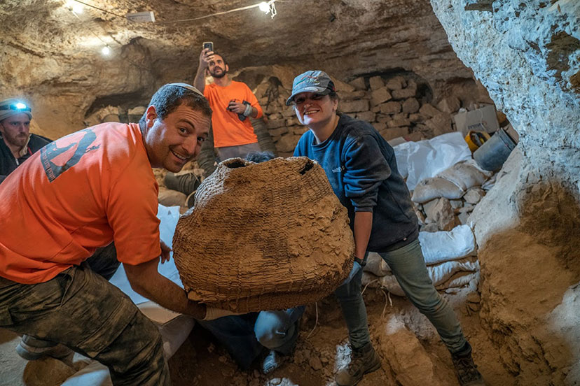 הארכיאולוגים חיים כהן וד"ר נעמה סוקניק עם הסל הקדום בעולם, כפי שנחשף במערת מורבעת. צילום: יניב ברמן, רשות העתיקות